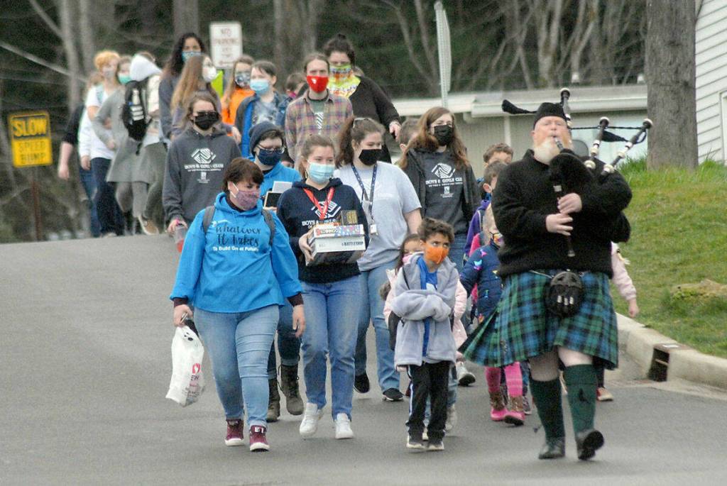 Olympic Peninsula News Group photo by Keith Thorpe/ Bagpiper Erik Evans of Port Angeles, right, leads children and staff members, including CEO Mary Budke down Francis Street from the old clubhouse of the Port Angeles Unit of the Boys & Girls Club to the new Turner Clubhouse on its first day of occupancy on March 5, 2021.