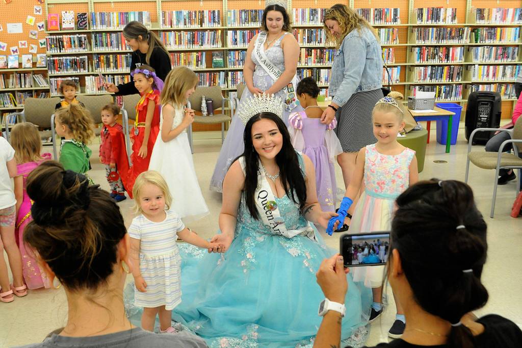 Sequim Gazette photo by Matthew Nash/ Sequim Irrigation Festival queen Ariya Goettling takes a photo with Parker and Finley during the North Olympic Library Systems Storytime with the Royalty event.