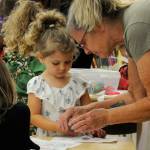 Sequim Gazette photo by Matthew Nash/ Sandi Shaw helps her granddaughter Sienna Shappie, 3, make a crown during the North Olympic Library Systems Storytime with the Royalty event. Shaw said she and granddaughters come all the time to the library.