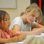Sequim Gazette photo by Matthew Nash/ Alyx Smith, left, and Elizabeth Tupper draw in their own mini-comics on July 31 inside Olympic Peninsula Academys gym for the North Olympic Library Systems Summer Reading Program.
