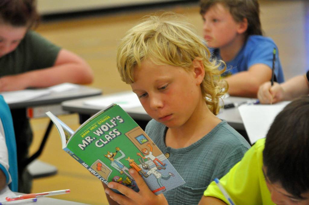 John John Audrain reads Mr. Wolfs Class during a make-your-own comic session from cartoonist Aron Nels Steinke.