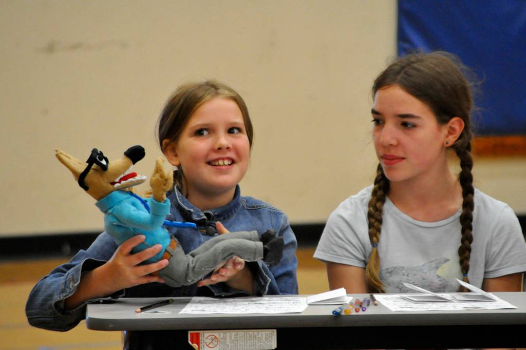 Ruby Sly-Hobson holds a puppet of Mr. Wolf while introducing herself during a lesson on how to make a comic book from cartoonist Aron Nels Steinke, who created the Mr. Wolf character after his time as a teacher.