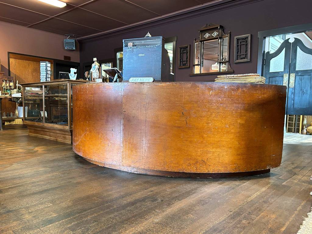 Sequim Gazette photo by Matthew Nash/ One centerpiece of the Carlsborg Store is its original front counter that Justin Pollak restored after it was covered in carpet, linoleum and fence boards.