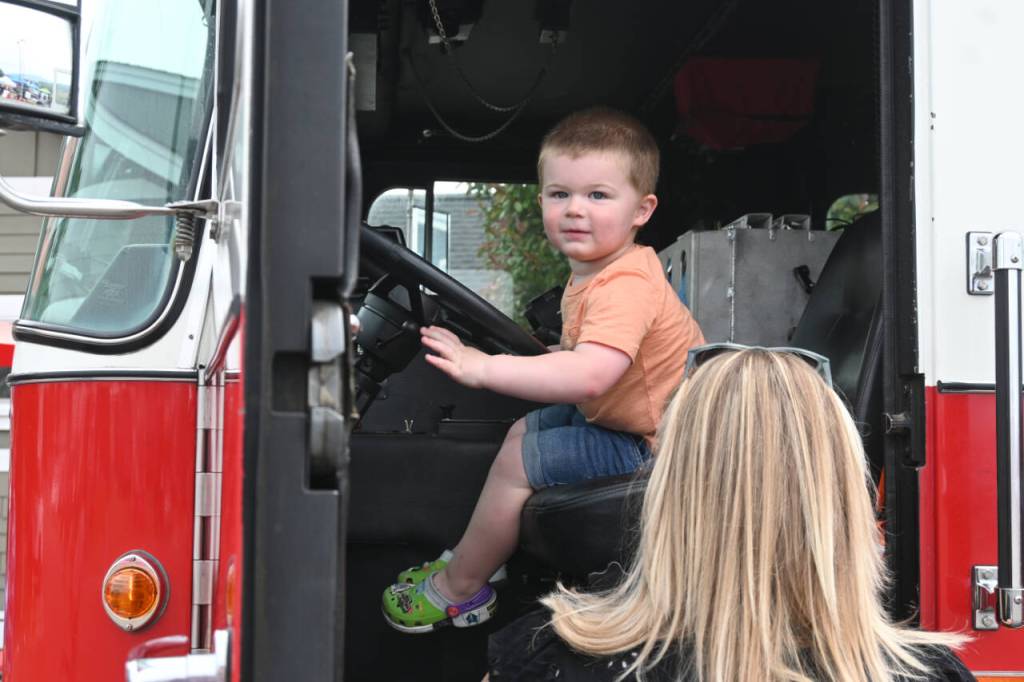 Sequim Gazette photo by Michael Dashiell / Walker Miller, 2, of Port Angeles, enjoys some time behind the wheel of a Clallam County Fire District 3 truck at the Unity of Effort event in Aug. 10.4col