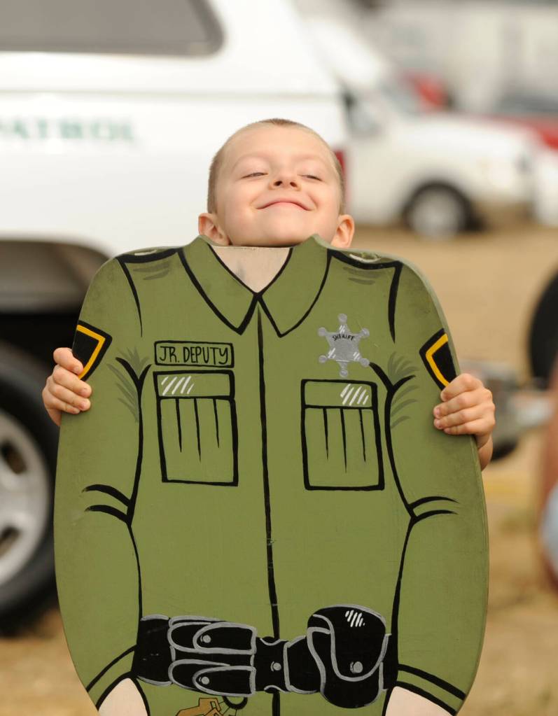 Sequim Gazette photo by Michael Dashiell / Daniel Derevianchuk, 5, of Port Angeles, looks for a growth spurt for his junior deputy role at the Unity of Effort event in Sequim on Aug. 10.