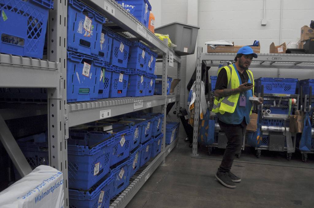 Sequim Gazette photo by Matthew Nash/ Jesse Corral, a Sequim Walmart associate, works to fill an online grocery pickup in the recently remodeled area. It moved from the west side of the building to the east side by the auto center.