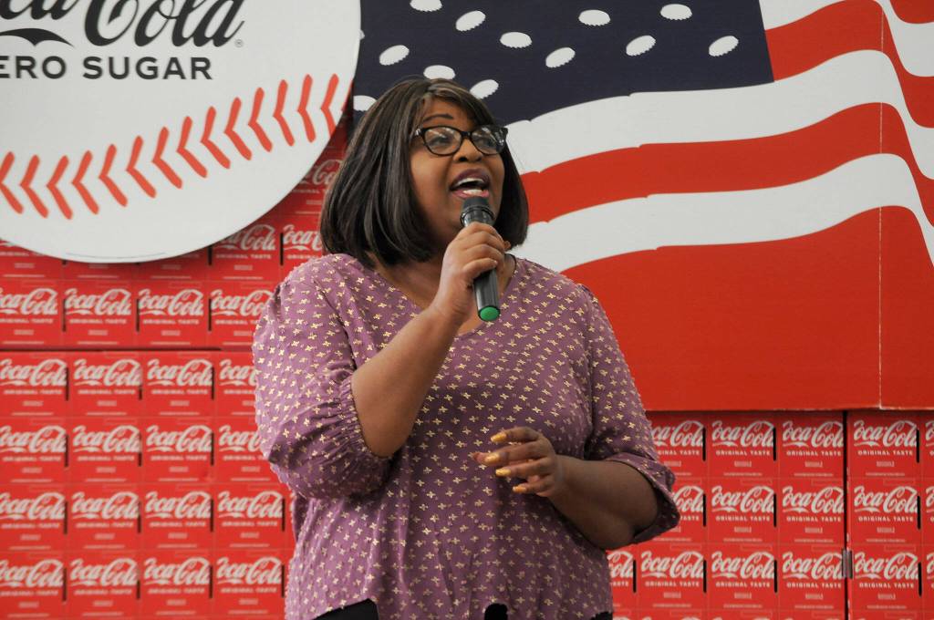 Sequim Gazette photo by Matthew Nash/ Mary Hailey sings the national anthem prior to a ceremony honoring work done for the Sequim Walmart remodel.