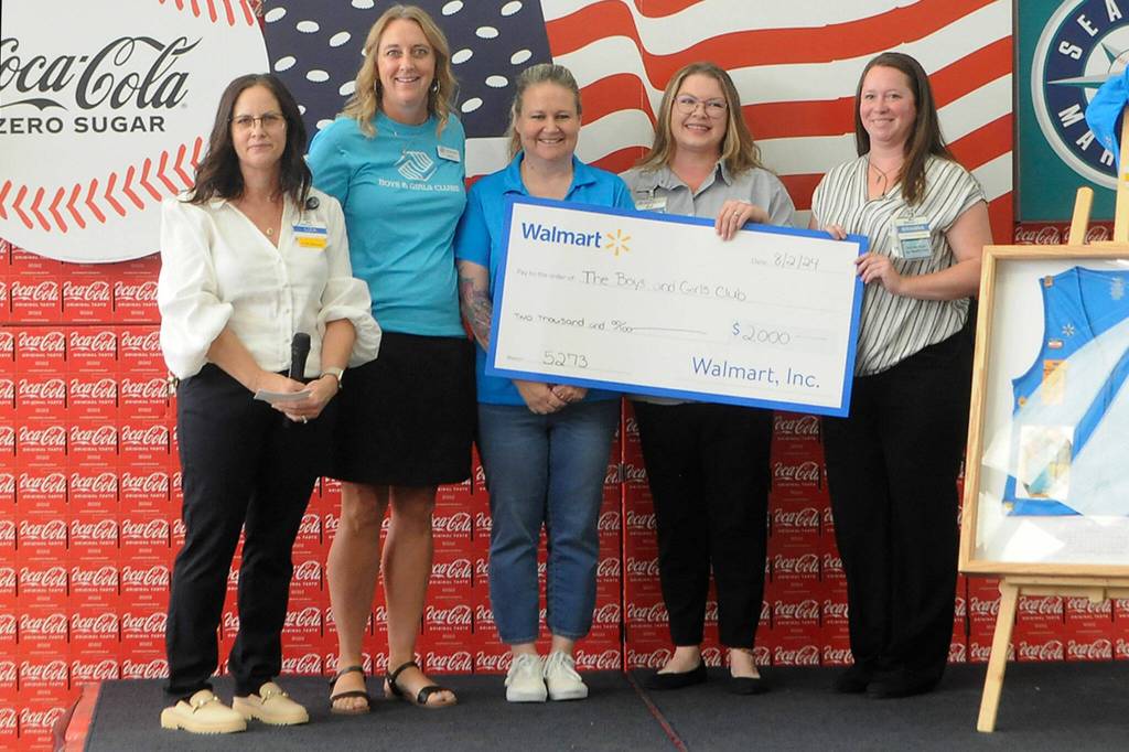 Sequim Gazette photo by Matthew Nash/ Boys & Girls Clubs of the Olympic Peninsula staffers accept a $2,000 donation from Sequim Walmart staff on Aug. 2.