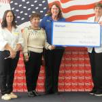 Sequim Gazette photo by Matthew Nash/ Dungeness Valley Health and Wellness representatives accept a $2,500 donation from Sequim Walmart staff on Aug. 2.