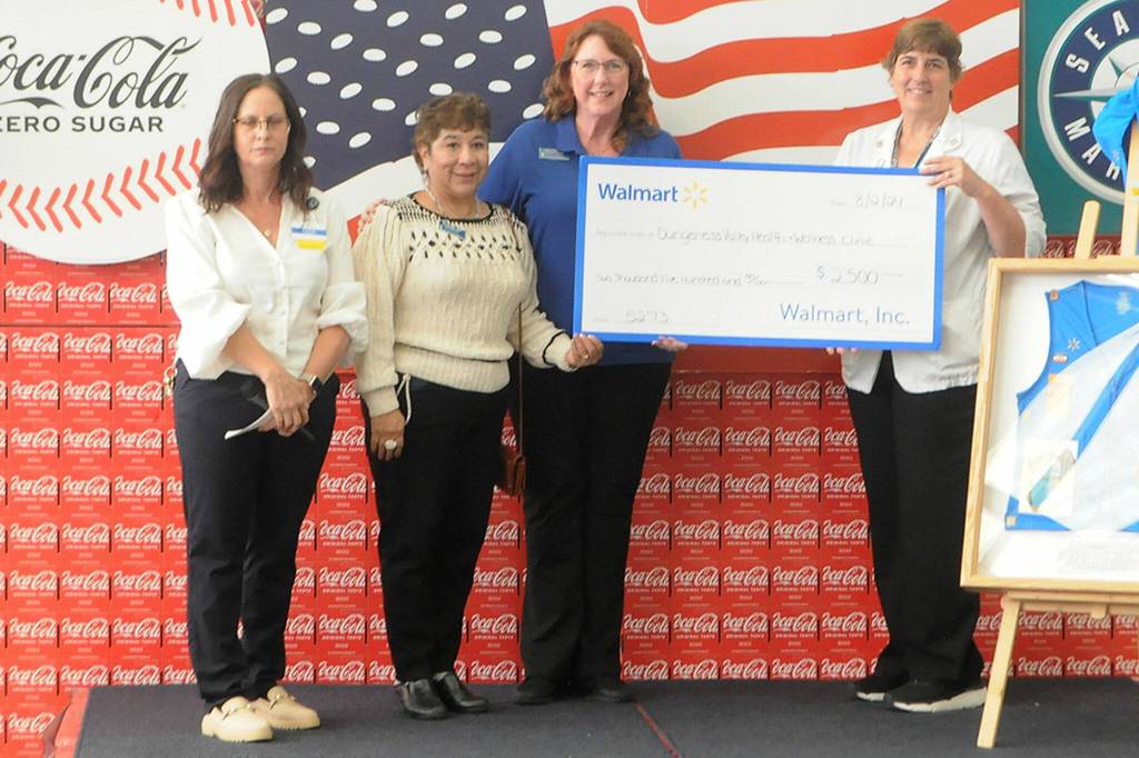 Sequim Gazette photo by Matthew Nash/ Dungeness Valley Health and Wellness representatives accept a $2,500 donation from Sequim Walmart staff on Aug. 2.