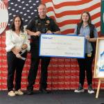 Sequim Gazette photo by Matthew Nash/ Deputy Police Chief John Southard accepts a $2,000 donation for the department from Sequim Walmart staff on Aug. 2.