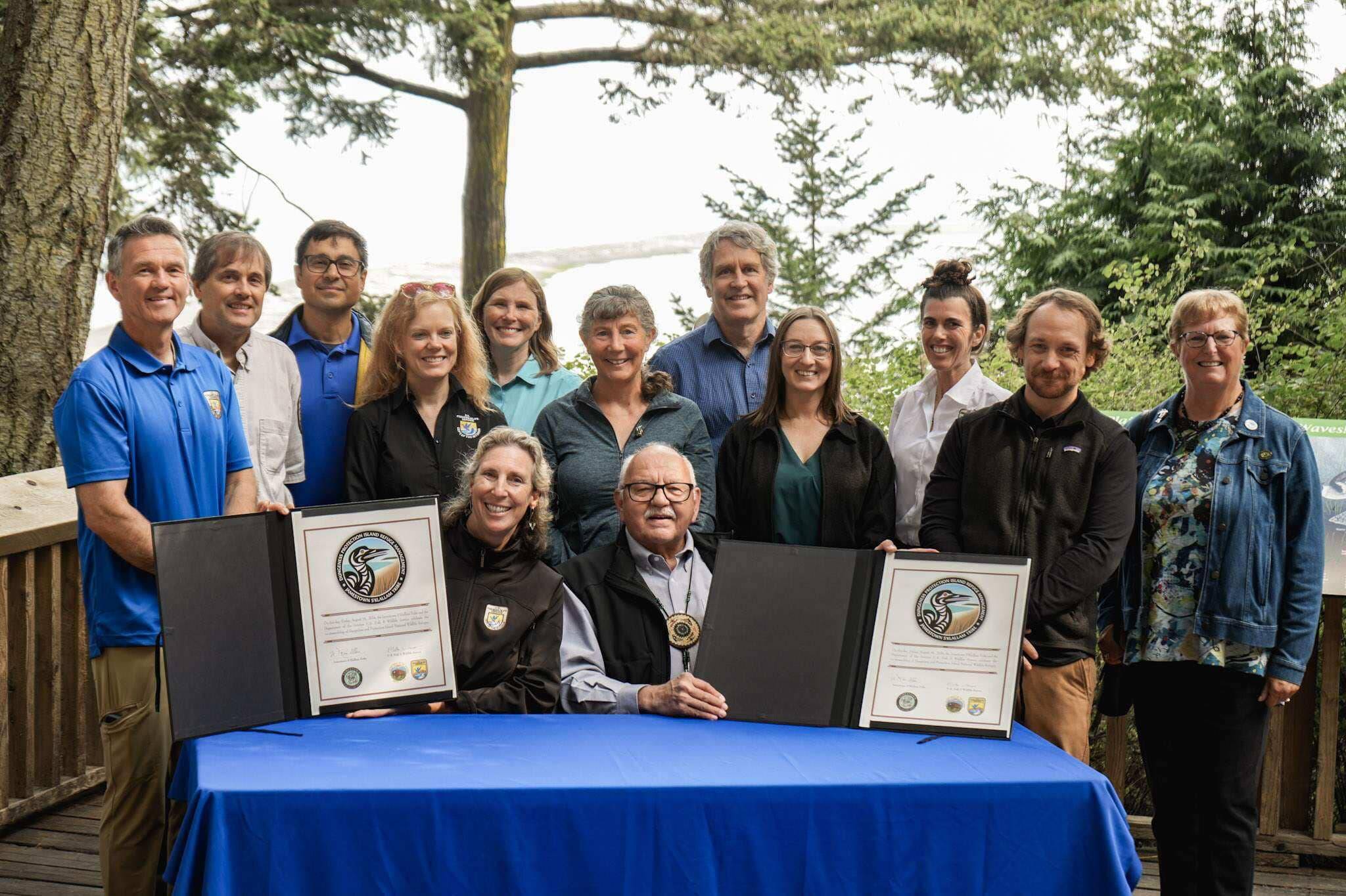 Photo by Jackie Johnson/Jamestown SKlallam Tribe
Martha Williams, director of the U.S. Fish & Wildlife Service, and Ron Allen, CEO and Tribal Chairman of the Jamestown SKlallam Tribe (both seated), celebrate the signing of a co-stewardship agreement for the Dungeness and Protection Island National Wildlife Refuges on Aug. 16.