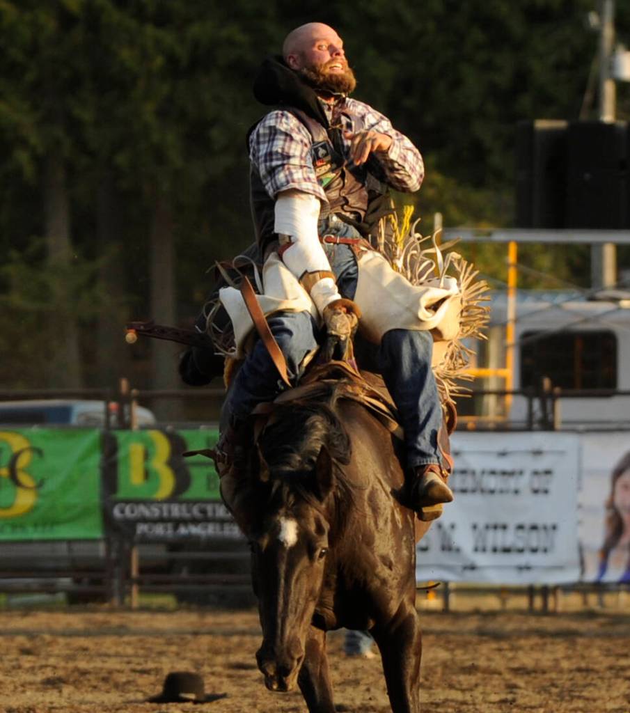 Sequim Gazette photo by Michael Dashiell / Despite nursing an injury, Kyle Bounds of Harrisburg, Oregon, holds on for a big score in the bareback riding portion of the Clallam County Fair Rodeo on Aug. 16. Bounds took first in the division.