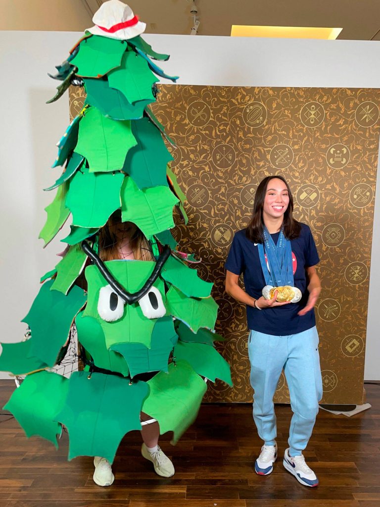 Photo courtesy Stanford Athletics/ As the Stanford Tree, Ruby Coulson of Sequim interviews Stanford swimmer Torri Huske, the universitys lone returning medalist who earned three gold medals and two silver in the Paris Olympics. for a photo as the Stanford Tree with alumni Katie Ledecky and Andrew Luck during a promotional event. Ledecky became the most decorated American female Olympian at the Paris Olympics. Luck also helped Coulson go to Paris so she could help promote the university and its athletes.