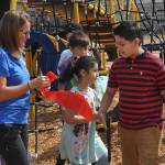Sequim Gazette photo by Matthew Nash/ Helen Haller Elementary principal Rebecca Stanton offers fourth grader Julian Mendoza a piece of the ribbon he cut to commemorate the installation of the schools new playground equipment the Crab Trap.