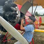 Keith Kossuth of Chino, Calif. works on his 1929 Travel Air during the Olympic Peninsula Air Affaire and Sequim Valley Fly-In. Poor weather and some water in his engine caused him to pause flights on Aug. 24, but he was flying by the end of the event and he said hed offer rides the next day.