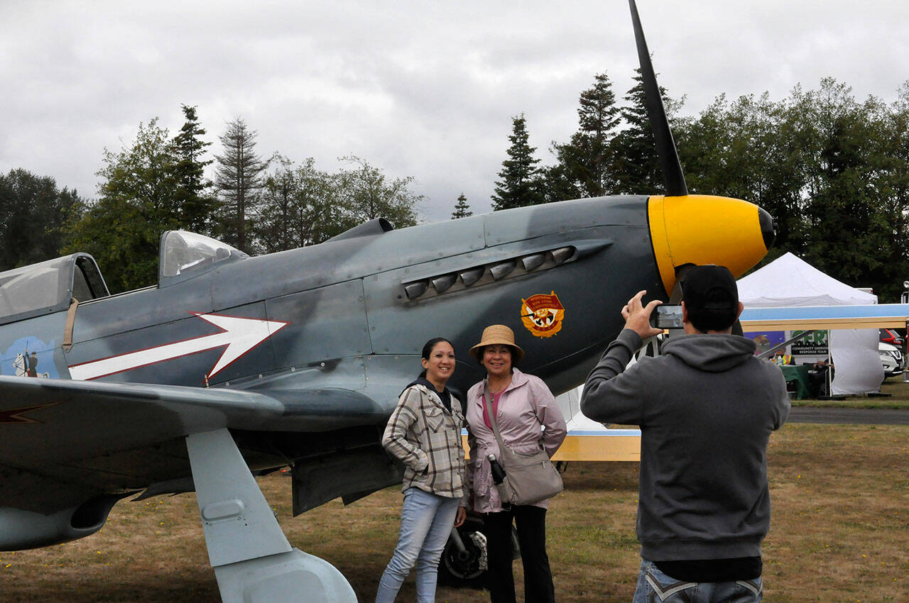 Sequim Gazette photos by Matthew Nash
Josh Crane of Sequim snaps a picture of his girlfriend Raechel Hayashi and his mom Kathleen Crane of Greenville, South Carolina at the Olympic Peninsula Air Affaire on Aug. 24. They stand by Bill Shepherds Yak-3, a reproduction World War II Russian airplane.