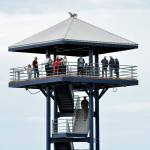 Photo by Keith Thorpe/Olympic Peninsula News Group / Visitors and dignitaries ascend the steps at the observation tower at Port Angeles City Pier on Aug. 21 after a ceremony to officially reopen the structure to the public. The tower was closed in November 2023 due to safety issues and structural concerns, prompting numerous repairs. Funding for the work, totaling more than $650,000, came from city lodging tax.