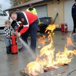 File photo by Keith Thorpe/Olympic Peninsula News Group
Beau Rossi, 2, of Sequim gets assistance from Clallam County Fire District 3 firefighter/paramedic Hayden Pyle with extinguishing an intentional propane fire during the Public Safety and Information Fair in 2023.
