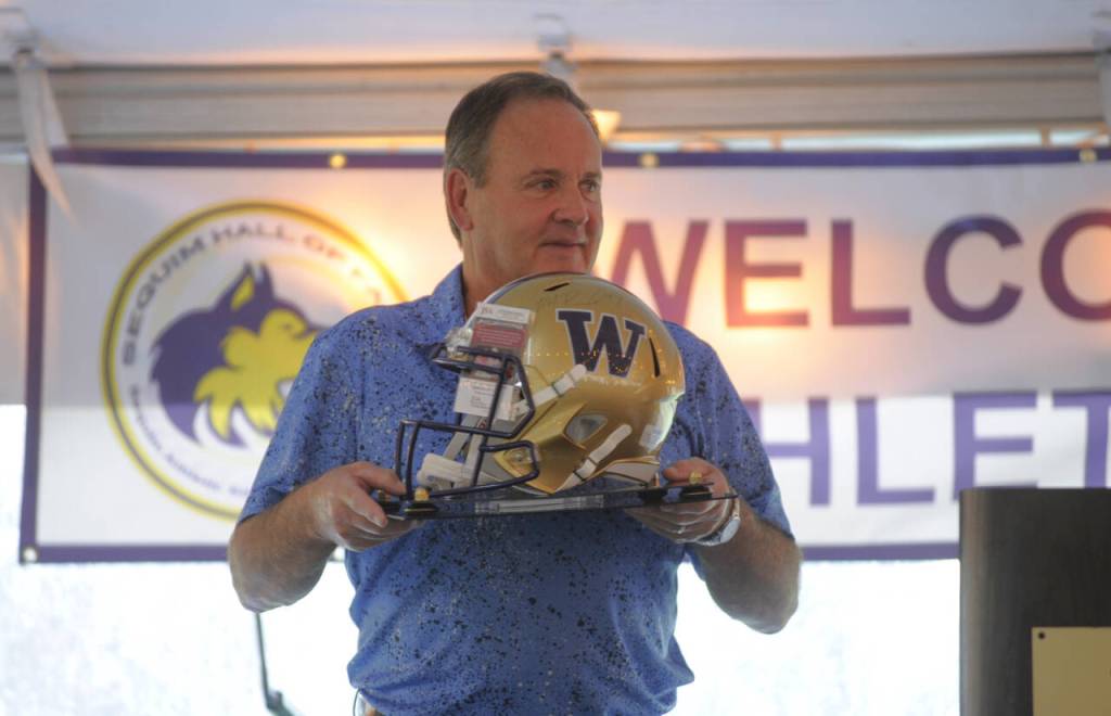 Sequim Gazette photo by Michael Dashiell / Kevin Kennedy, one of the key organizers of the 2024 Sequim Athletic Hall of Fame event, holds a helmet signed by former University of Washington quarterback Michael Penix.