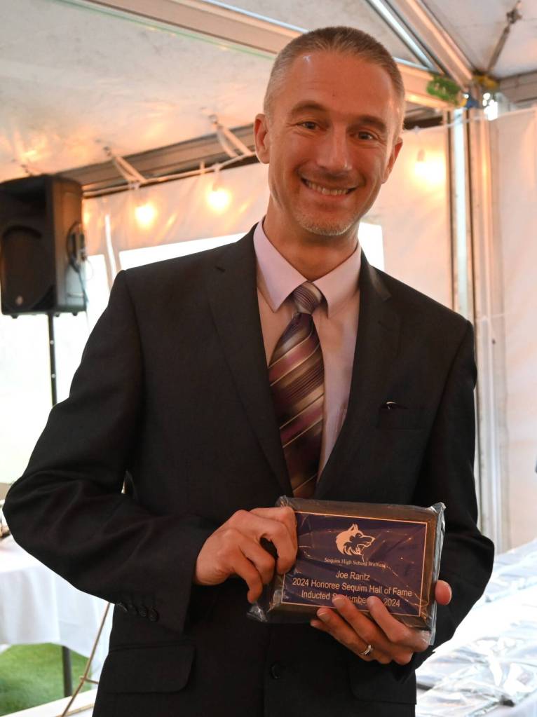Sequim Gazette photo by Michael Dashiell / Chris Willman accepts a 2024 Sequim Athletic Hall of Fame plaque on behalf of his grandfather Joe Rantz, who along with the 1936 University of Washington eight-man crew team won gold at the 1936 Olympic Games.