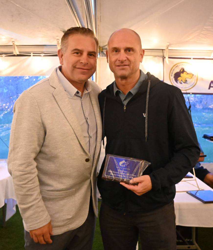 Sequim Gazette photo by Michael Dashiell / Ryan Kaps, right, accepts his 2024 Sequim Athletic Hall of Fame honors from Hall president Derrin Doty on Sept. 14.