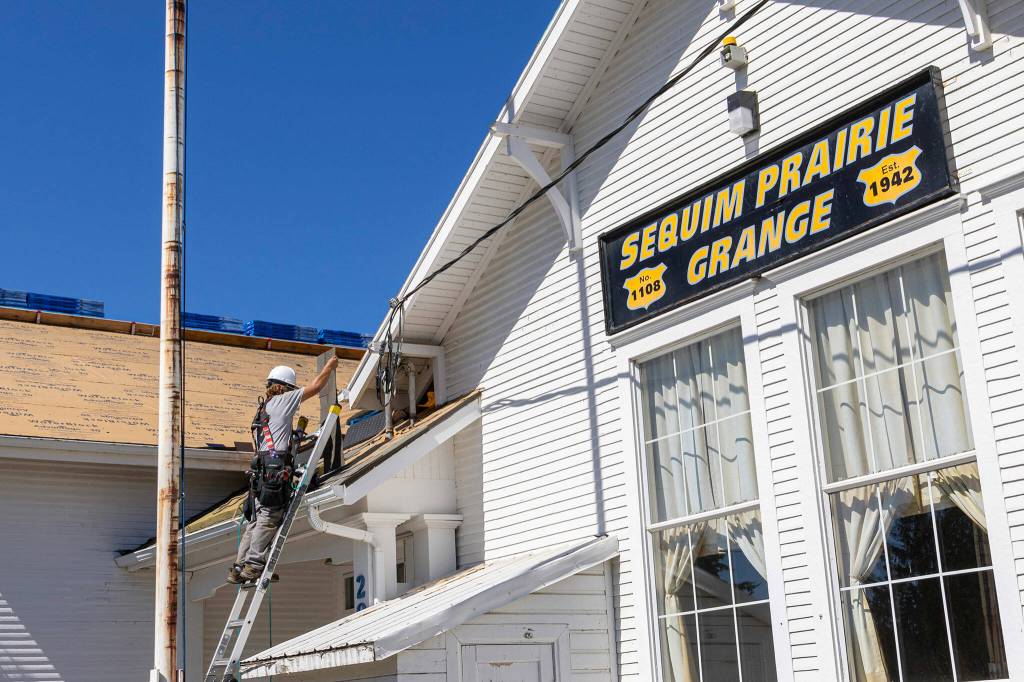 Photo courtesy of Sherrie Cerutti
BMC Roofing crew members place new shingles on Aug. 30 atop the Sequim Prairie Grange.