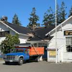 Sequim Gazette photo by Matthew Nash/ BMC Roofing crews work on Aug. 28 to replace a portion of the roof of the Sequim Prairie Grange. It should be completed early this week.