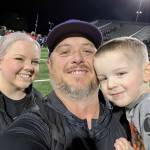 Photo courtesy of Ian Henley / New Sequim athletic director/head football coach Ian Henley takes a family photo with his wife Jessica and son Rhys after a football game.