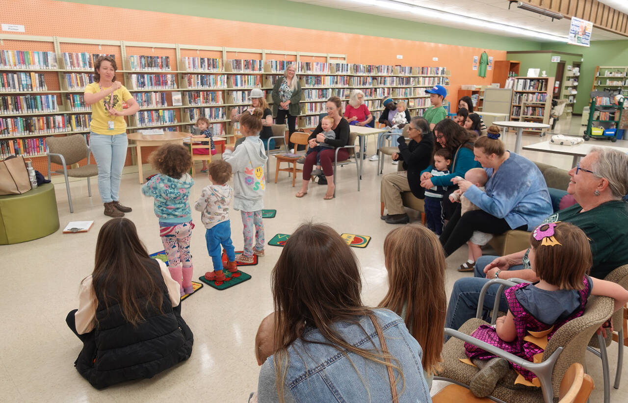 Photo courtesy of North Olympic Library System / At left, Charlotte McGrew  youth services librarian for the North Olympic Library System, leads a Family Storytime program. Free fall programs for all ages begin in September at the Sequim Library.