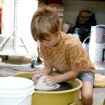 Eliott Carey, 5, shapes a mound of clay on a potter’s wheel on the patio of Peninsula College’s ceramics studio Saturday at its second Fall Spectacular. Playing with clay was one of many activities for children, families and adults at the event, which included tours of classrooms and introductions to courses and fields of study, Port Angeles Farmers Market booths, live music and an exhibition of art by college faculty. The event was a way for the people to learn about Peninsula College, meet faculty and staff and connect with community resources. Fall quarter at the college starts Sept. 26. (Paula Hunt/Peninsula Daily News)
