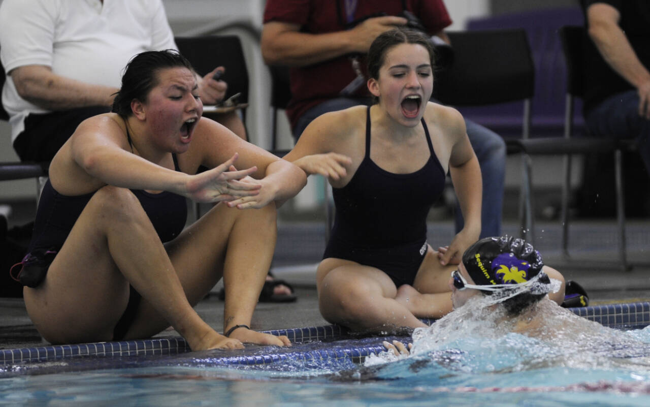 Sequim Gazette photo file by Michael Dashiell / Sequims Melia Nelson, left, and Ava Shinkle cheer on teammate Annie Ellefson in the 100 breaststroke as the Wolves take on Bremerton at home in a 2023 league meet.
