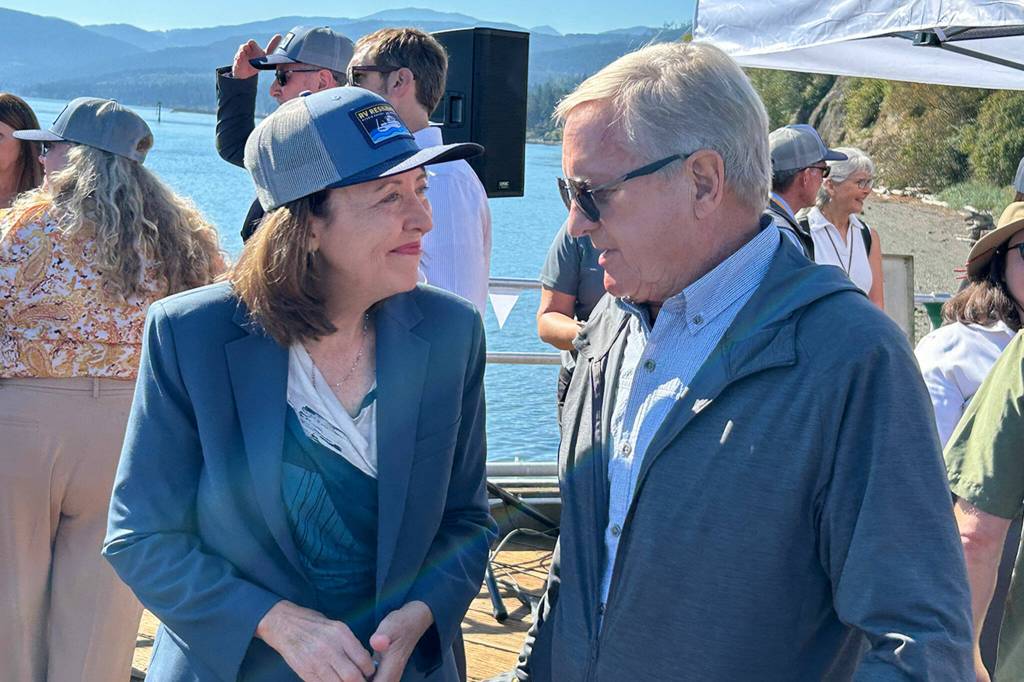 Sequim Gazette photo by Matthew Nash/ Senator Maria Cantwell, sporting an RV Resilience cap, speaks with U.S. Representative Steve Tharinger after the christening of the new hybrid vessel.