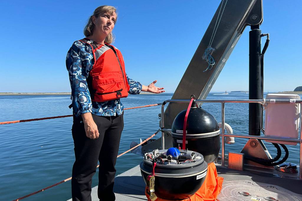 Sequim Gazette photo by Matthew Nash
Ruth Branch, a PNNL earth scientist, stands by a WITT wave energy converter buoy, one of the devices that could be used by the RV Resilience, the Department of Energys first hybrid vessel based in Sequim.