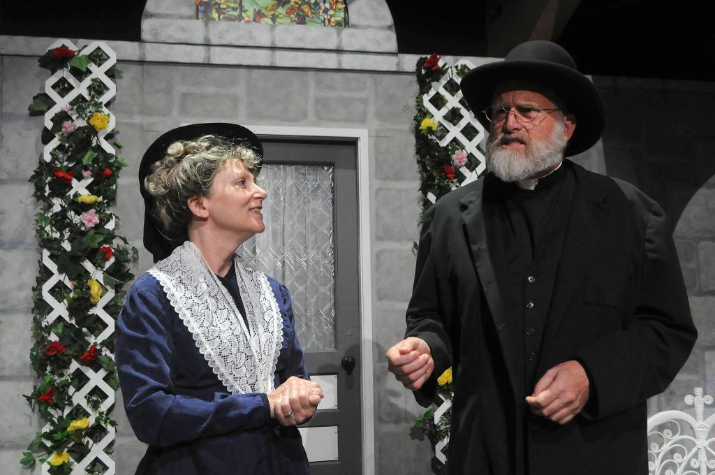 Sequim Gazette photo by Matthew Nash/ Miss Prism (Diane Smith) and Dr. Chasuble (Pete Griffin) discuss marriage during a scene in The Importance of Being Earnest.