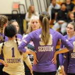 Sequim Gazette photo by Michael Dashiell / Sequim coach Jennie Webber Hielman (background) talks with players during a first set timeout as the Wolves take on Bainbridge on Sept. 19.
