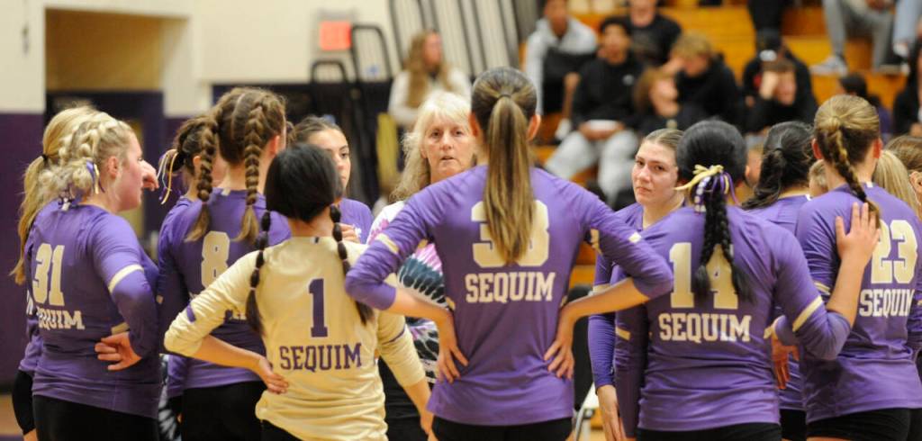 Sequim Gazette photo by Michael Dashiell / Sequim coach Jennie Webber Hielman (background) talks with players during a first set timeout as the Wolves take on Bainbridge on Sept. 19.