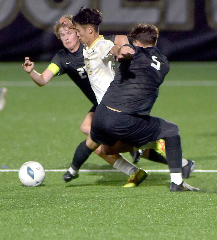 Photo by Keith Thorpe/Olympic Peninsula News Group / Peninsulas Koya Kimura, center, breaks through the defense of Everetts Noah Harrison-Russell, left, and Dilon Spahia on Sept. 18 in Port Angeles.