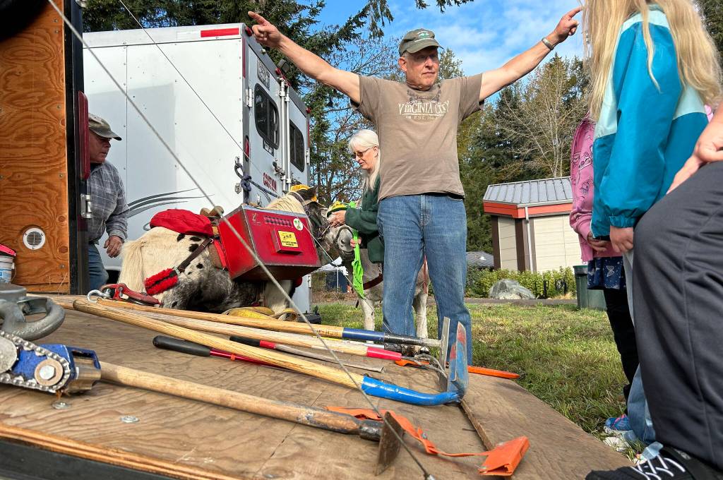 Sequim Gazette photo by Matthew Nash/ Jim Hollatz with the Back Country Horsemen talks to children at the Dungeness River Festival about the tools their volunteers use to clear trails at all angles.