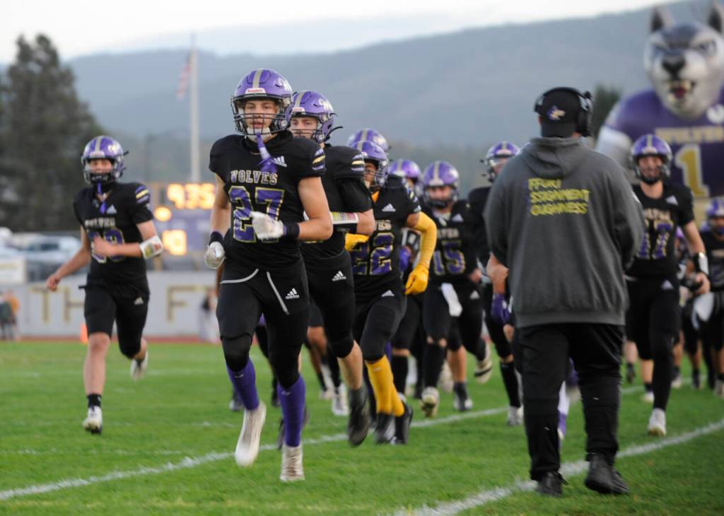Sequim Gazette photo by Michael Dashiell / Sequim's Simon Skribner (27) helps lead the Wolves onto the field at their 2024 Homecoming game against Port Angeles on Sept. 27.