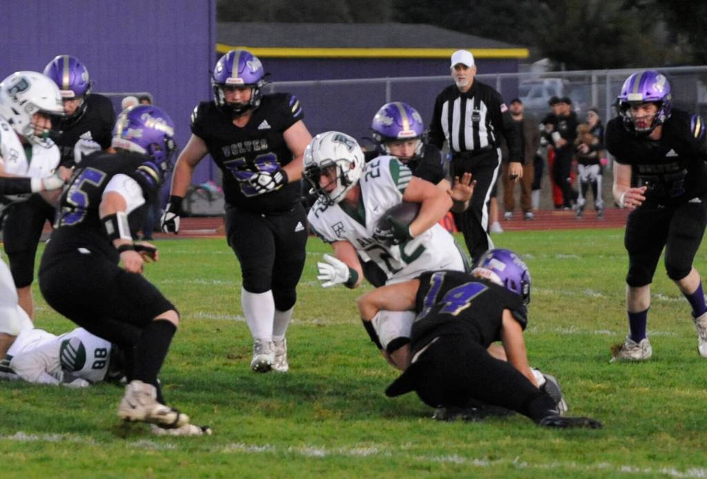 Sequim Gazette photo by Michael Dashiell / Sequims Zeke Schmadeke (14) puts the initial hit on Port Angeles Dylan Mann (22) in the first half of the Wolves-Roughriders match-up on Sept. 27.