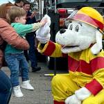 Sequim Gazette photo by Matthew Nash/ Maverick Santjer gives Sparky the Fire Dog a high-five with help from his mom Marissa at the Sequim Public Safety Fair in Carrie Blake Community Park on Oct. 5.