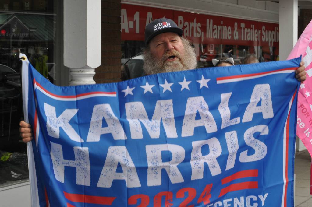 Paul Kolesnikoff of Port Angeles walks during the Womens March for Humanity in downtown Sequim holding a Kamala Harris flag, saying he really wants her to become president. He also said Harris with President Joe Biden did a good job pulling the U.S. out of the Covid-19 pandemic.
