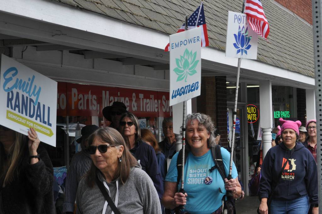 Sequim Gazette photo by Matthew Nash/ Walkers hold signs and march along Washington Street for the Womens March for Humanity on Oct. 5. in downtown Sequim.
