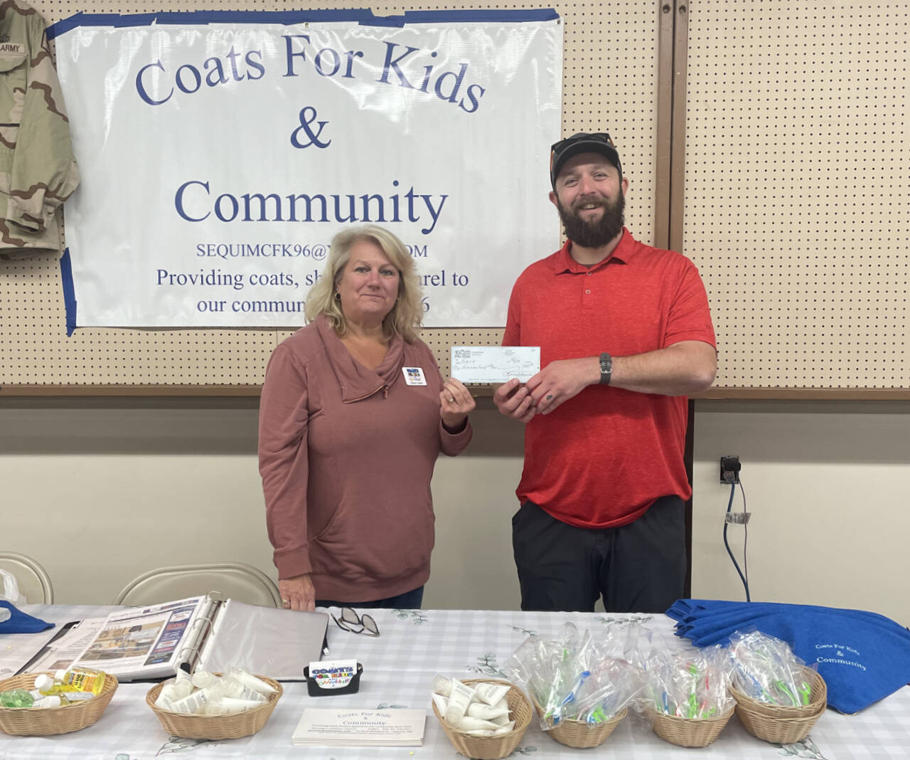 Photo courtesy of Coast For Kids & Community
Levi Douglas, administrator with the Northwest Veterans Resource Center, accepts a donation from Karen Lewis of the Coats For Kids & Community group.