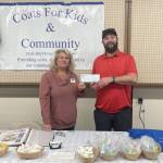 Photo courtesy of Coast For Kids & Community
Levi Douglas, administrator with the Northwest Veterans Resource Center, accepts a donation from Karen Lewis of the Coats For Kids & Community group.