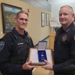 Photo courtesy John Southard/ Sequim police chief Mike Hill presents officer Mark Poole with a Lifesaving Award on Oct. 14 for preventing a man from jumping from the River Road bypass in August.