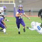 Sequim Gazette photo by Matthew Nash/ Zeke Schmadeke rushes to a first down on Saturday against the Olympic Trojans. The game was delayed a day due to a power outage on Friday night.