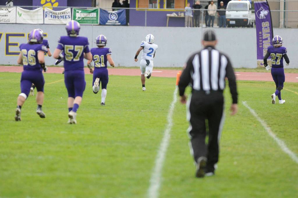 Sequim Gazette photo by Matthew Nash/ Olympics Chace Webster rushes to an 80-yard touchdown in the second quarter against the Sequim Wolves on Oct. 19. The Trojans won 28-7.