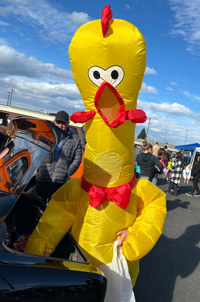 Sequim Gazette photo by Matthew Nash/ Eleven-year-old Eli Himmelberger visits the Olympic Peninsula Rat Racers Trunk-or-Treat on Oct. 26 at the Sequim Village Shopping Center dressed as a giant inflatable chicken.